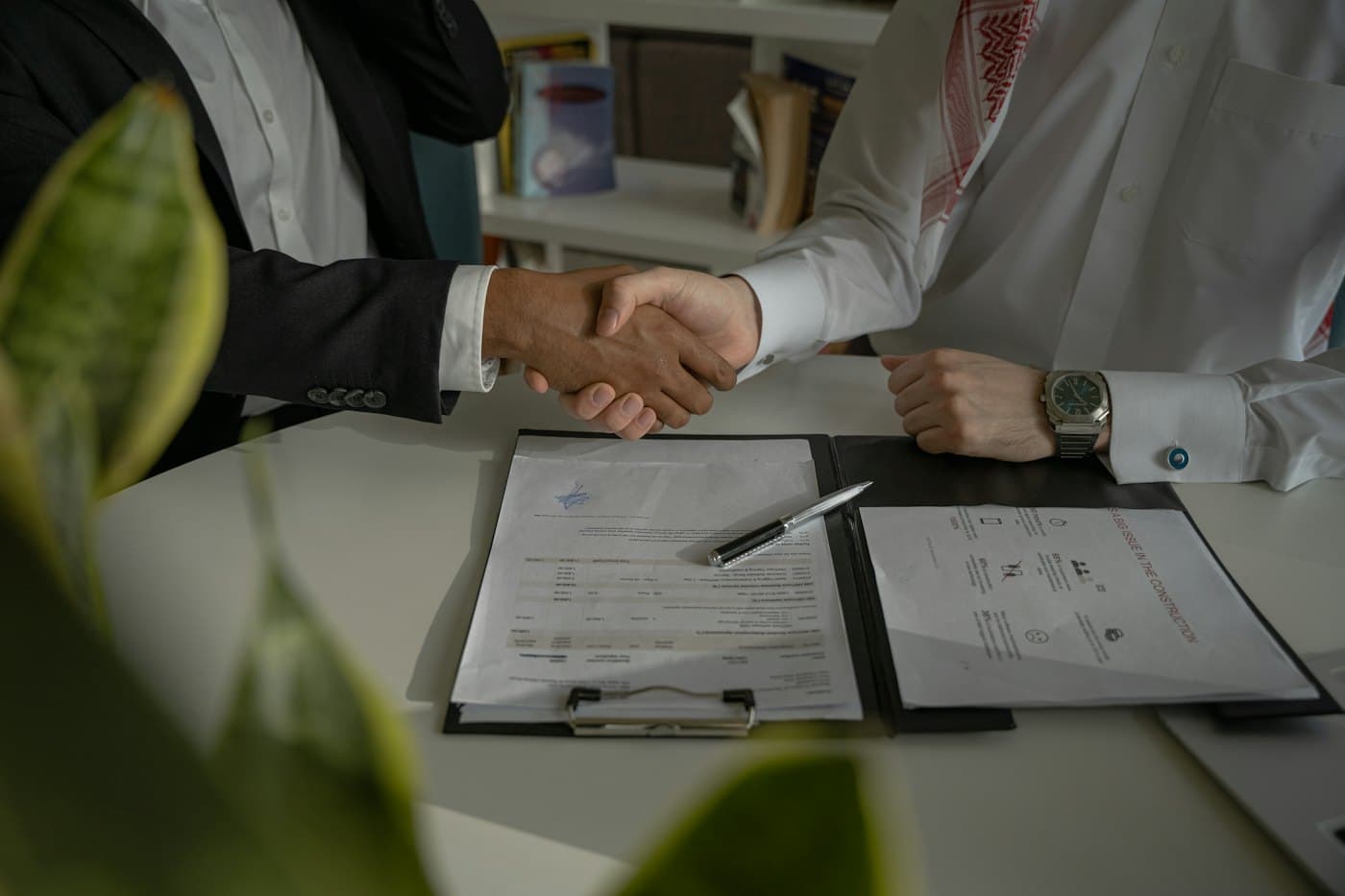 Poignée de main sur un devis signé entre un artisan et son client